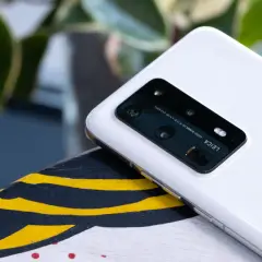 Biały smartfon z aparatem Leica na pokładzie, działający na systemie emui 10.1, leży na ozdobnej powierzchni.