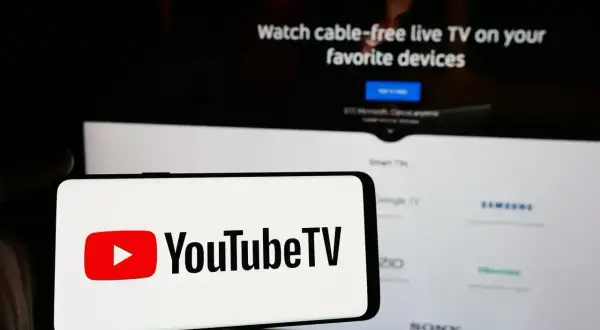 Smartfon z logo YouTube TV na tle ekranu telewizora z napisem "Watch cable-free live TV". Aktualizacja YouTube za darmo to świetna opcja.