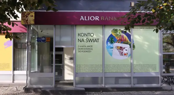 Alior Bank zaprasza na konto jakże osobiste z kartą dopasowaną do podróży. Reklama z jaszczurką i palmami.
