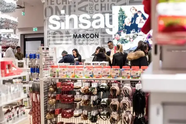 W Sinsay można płacić Blikiem. W sklepie Sinsay klienci robią zakupy, a na półkach widać akcesoria i drobne zabawki.