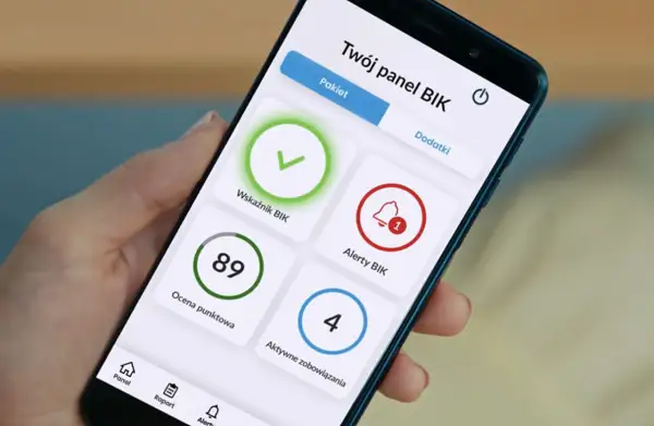 Na ekranie telefonu widać panel BIK z alertami. Widoczny jest wskaźnik BIK, ocena punktowa 89, alerty BIK z powiadomieniem oraz aktywne zobowiązania.