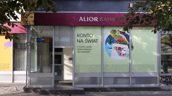 Alior Bank zaprasza na konto jakże osobiste z kartą dopasowaną do podróży. Reklama z jaszczurką i palmami.
